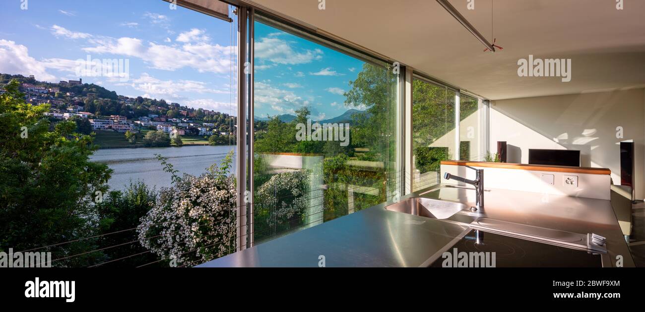 Intérieur de salon avec canapé et vue de rêve sur un étang suisse Banque D'Images