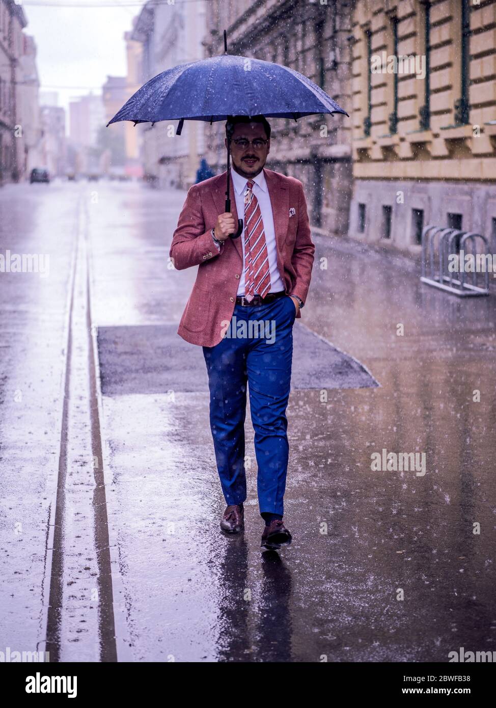 Homme d'affaires avec parapluie par temps pluvieux Photo Stock - Alamy
