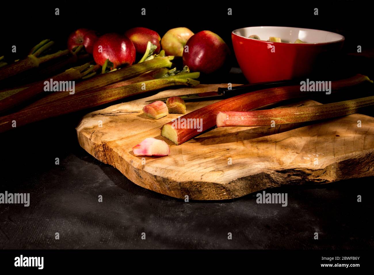 Rhubarbe et pommes fraîches sur la planche à découper. Banque D'Images
