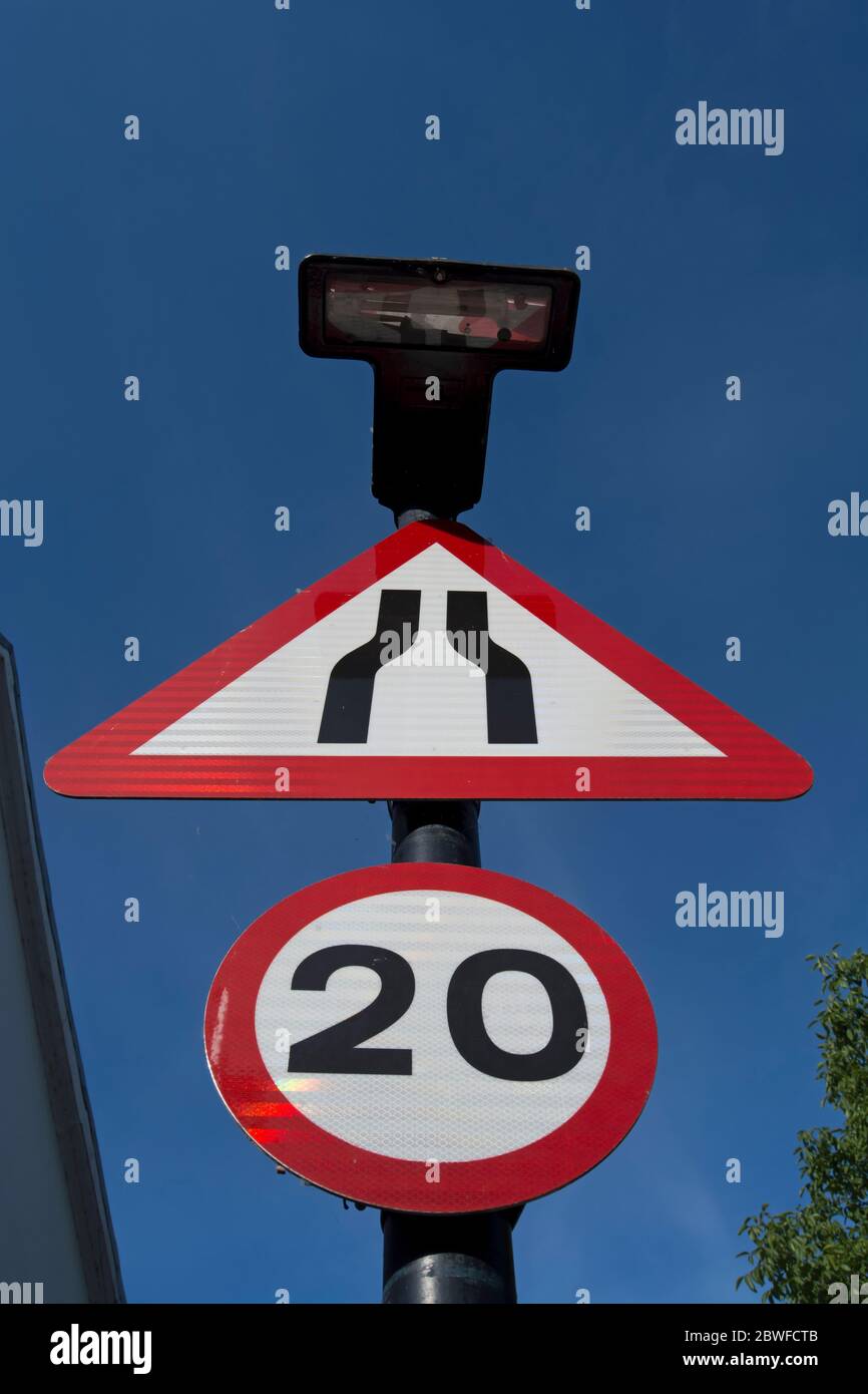 panneaux de signalisation indiquant le rétrécissement de la route devant vous et une limite de vitesse de 20 mph Banque D'Images