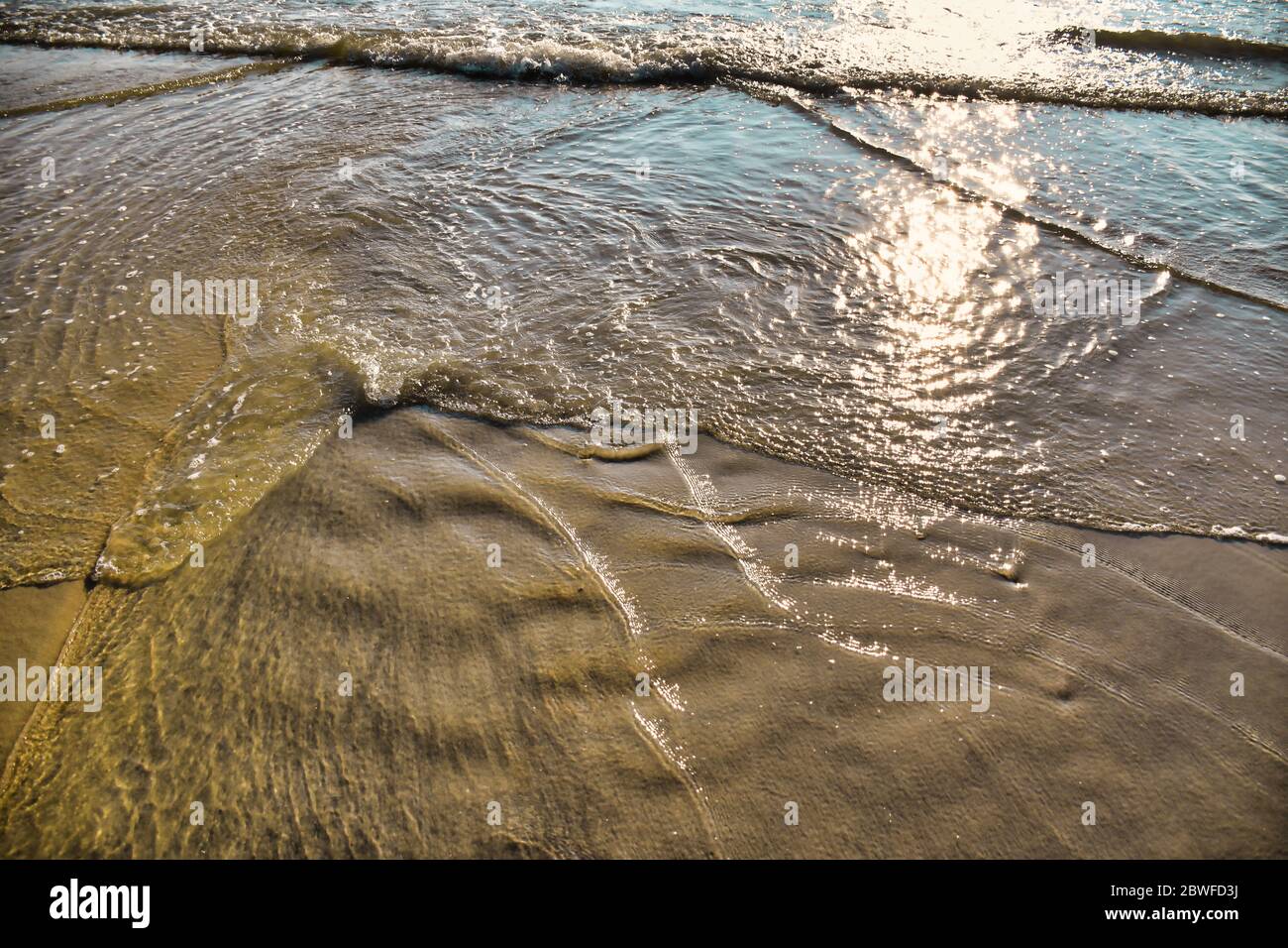 L'eau de la mer d'Andaman forme différentes lorsqu'elle atteint la plage de sable de Cenang de Langkawi Banque D'Images