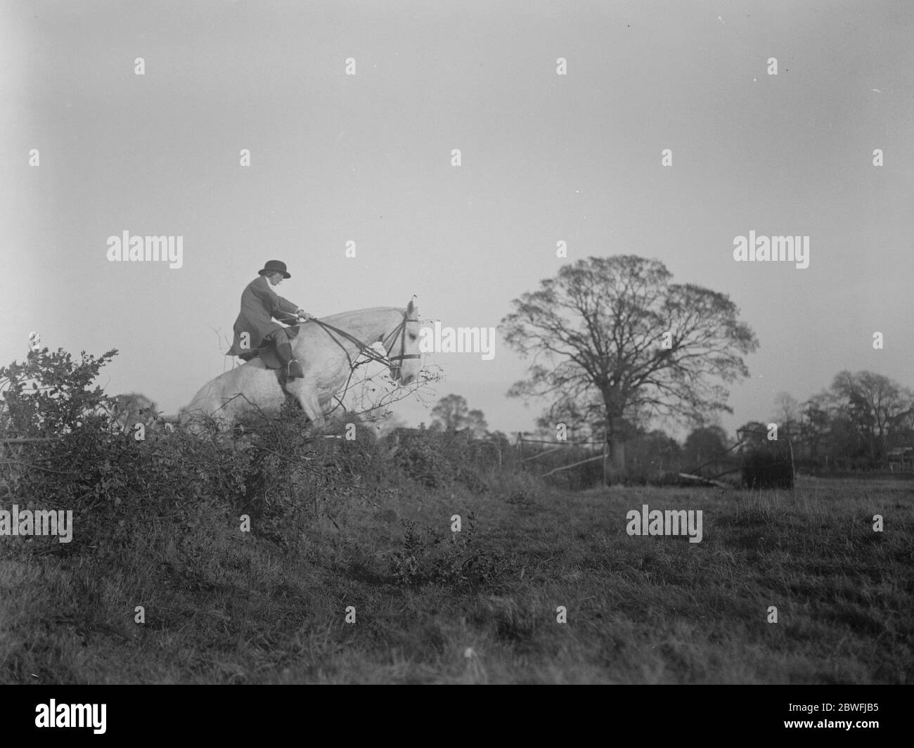 Draghounds de la brigade de ménage rencontrez les Draghounds de la brigade de ménage rencontré à Stoke Green House , Stoke Poges , la résidence de Lady Currie . Ici, une femme suiveuse peut être vu prendre une clôture 10 novembre 1923 Banque D'Images