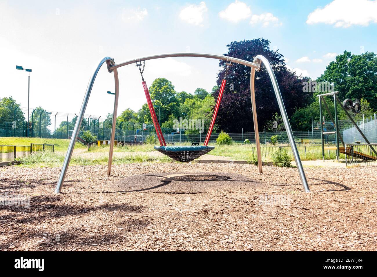 Une balançoire dans un terrain de jeu pour enfants est vide et calme car personne n'est autorisé à l'utiliser en raison de la pandémie du coronavirus. Banque D'Images