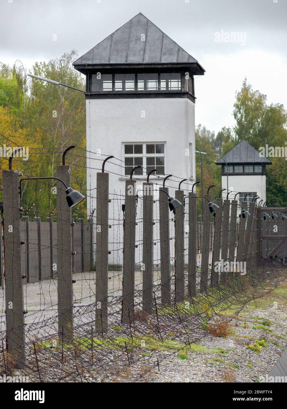 Clôtures électrifiées à barbelés et tour de surveillance de la garde au camp de concentration de Dachau. C'était le premier camp de concentration nazi et était un prototype f Banque D'Images