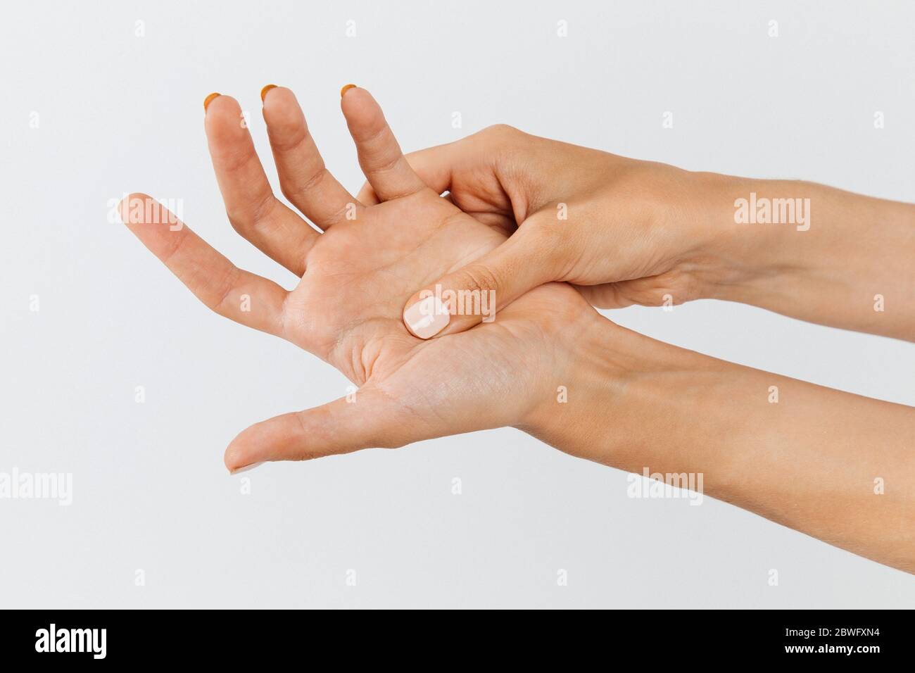 Gros plan des bras féminins tenant sa paume douloureuse provoquée par le travail prolongé sur l'ordinateur, portable.syndrome du tunnel carpien, arthrite, disea neurologique Banque D'Images