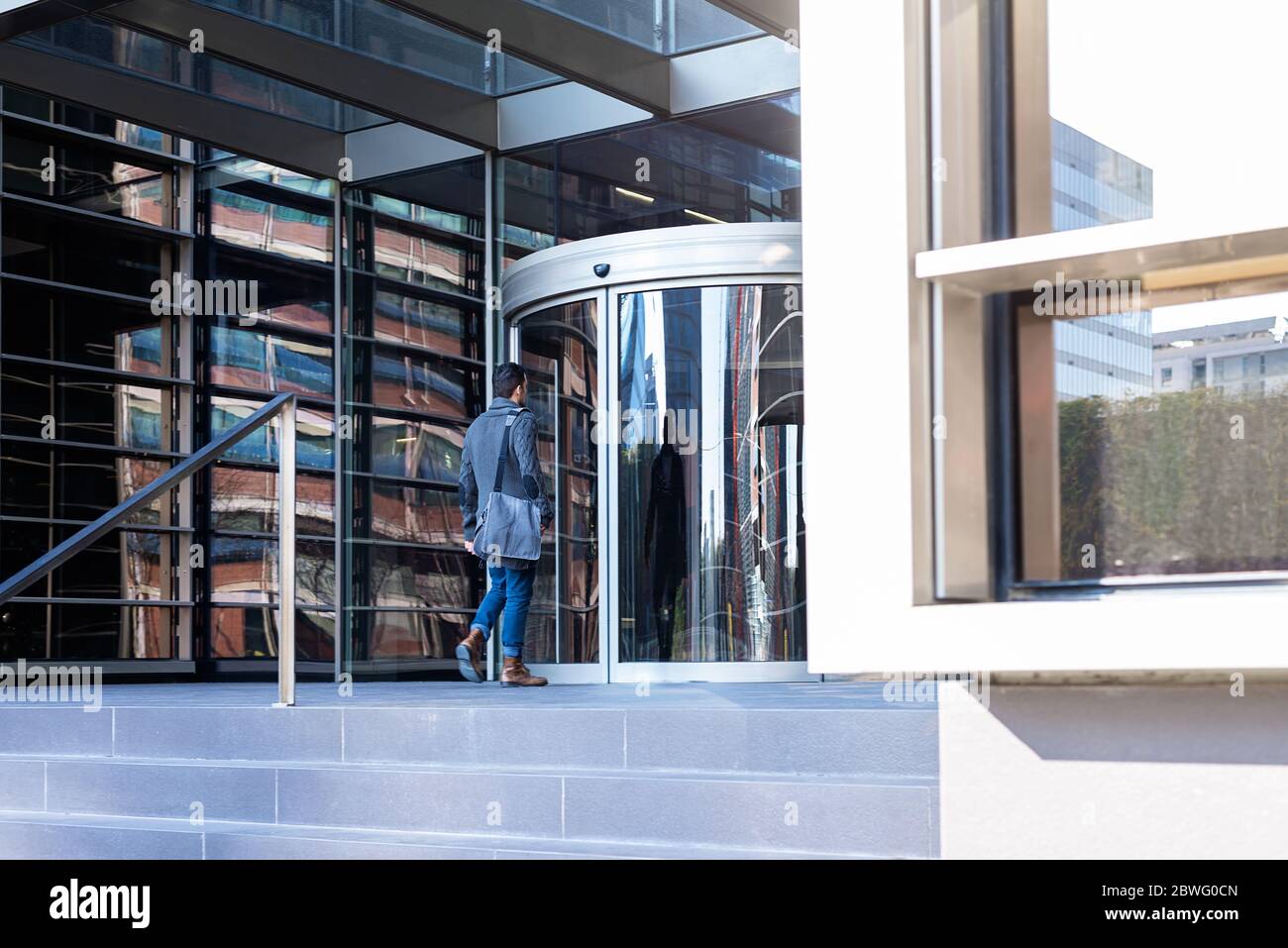 Jeune cadre entrant dans un immeuble de bureaux Banque D'Images