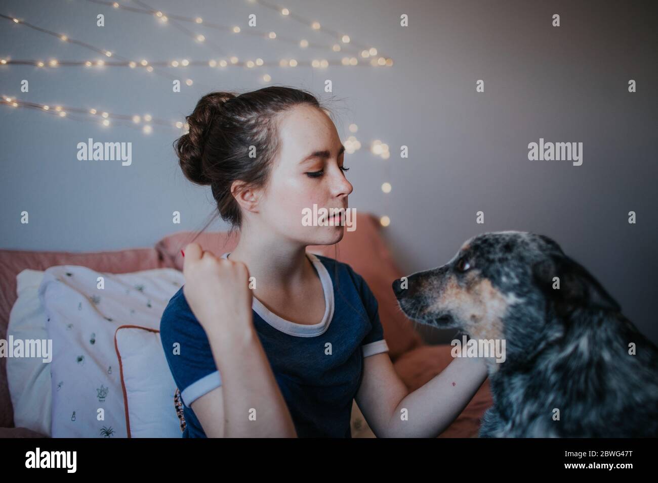 portrait d'une fille intermédiaire avec son chien sur le lit Banque D'Images