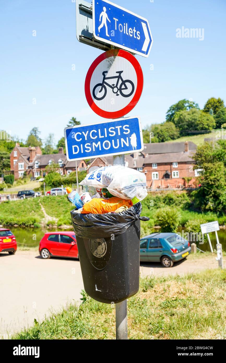 Gros plan sur un bac à litière du Royaume-Uni rempli de déchets dans un endroit de beauté de campagne au bord de la rivière. Les visiteurs d'été apportent les déchets et les déchets en excès dans les poubelles du conseil local Banque D'Images