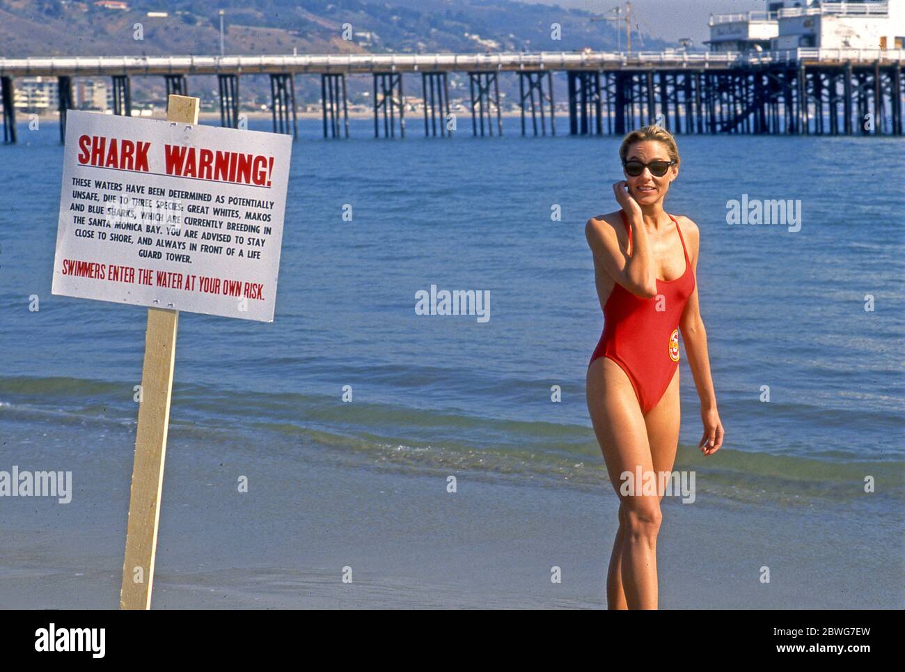 L'actrice Shawn Weatherly réagit à un signe d'avertissement des requins tout en filmant un épisode de Baywatch près de la jetée de Malibu à Los Angeles, en Californie Banque D'Images