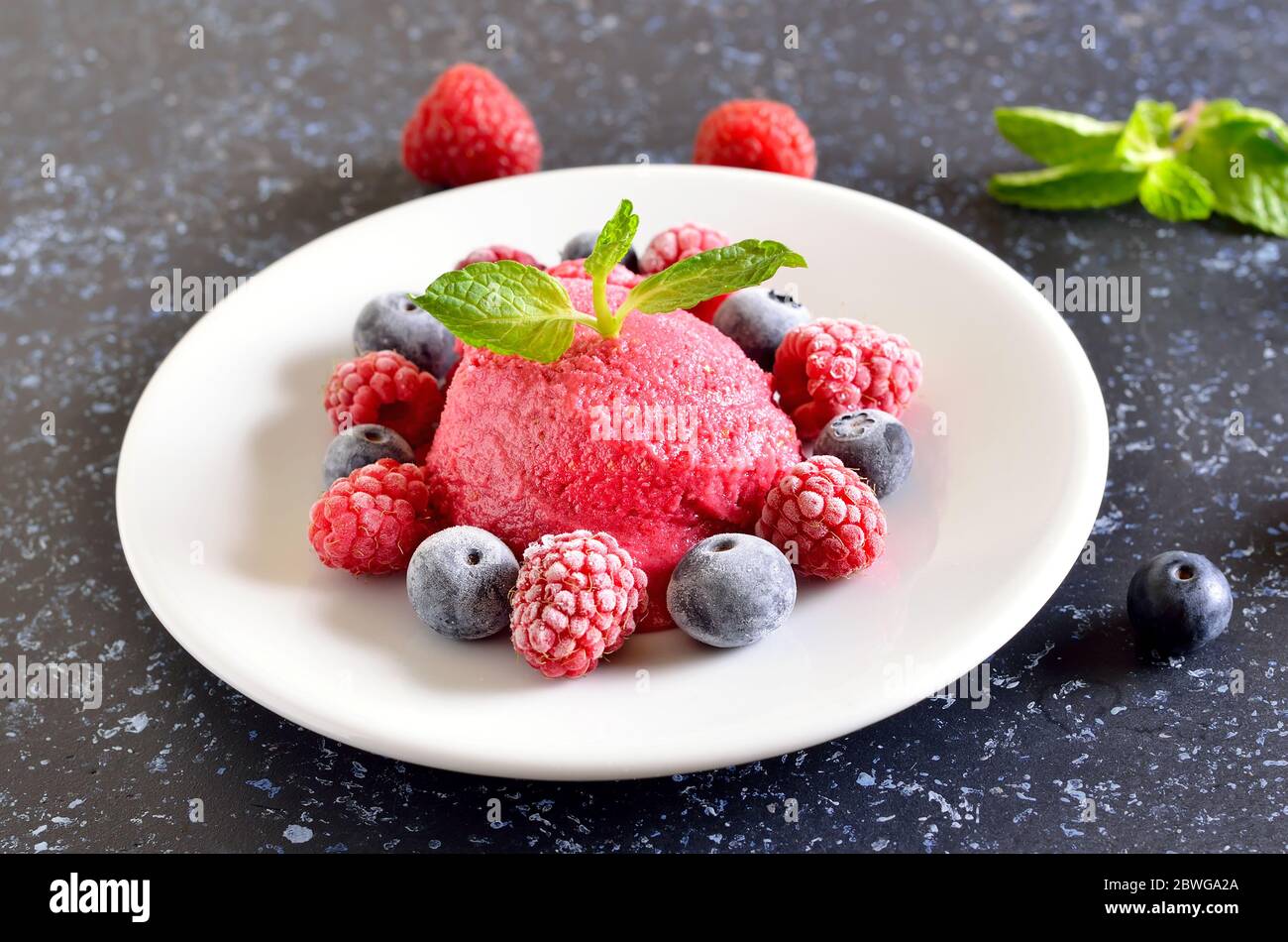 Sorbet framboise sur plaque sur fond de pierre sombre, vue rapprochée Banque D'Images