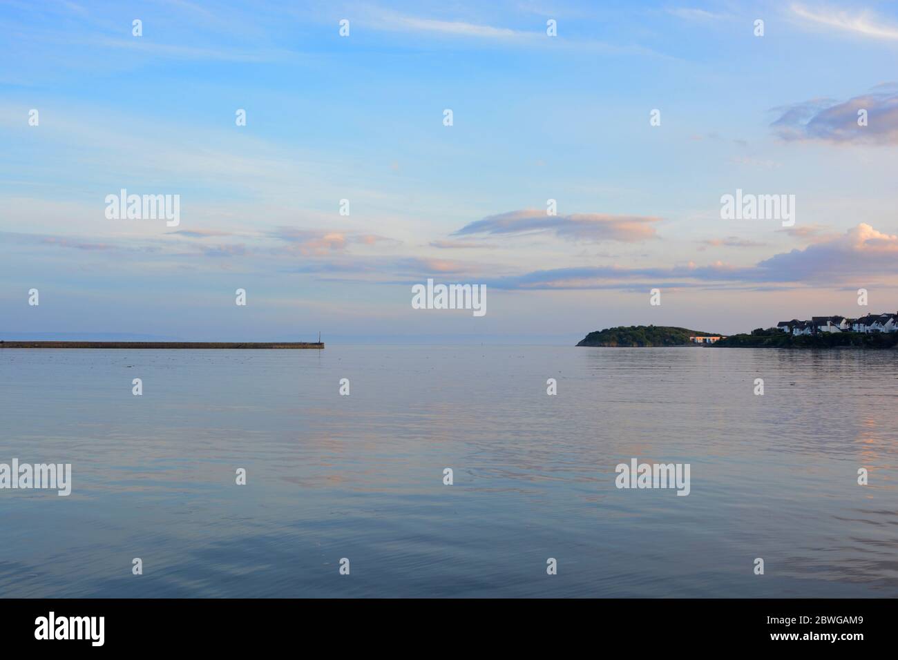 Barry, pays de Galles, la chaussée et point à l'île Barry à l'horizon. Marée haute avec le coucher du soleil et et nuage éparpillés à travers le ciel. Banque D'Images