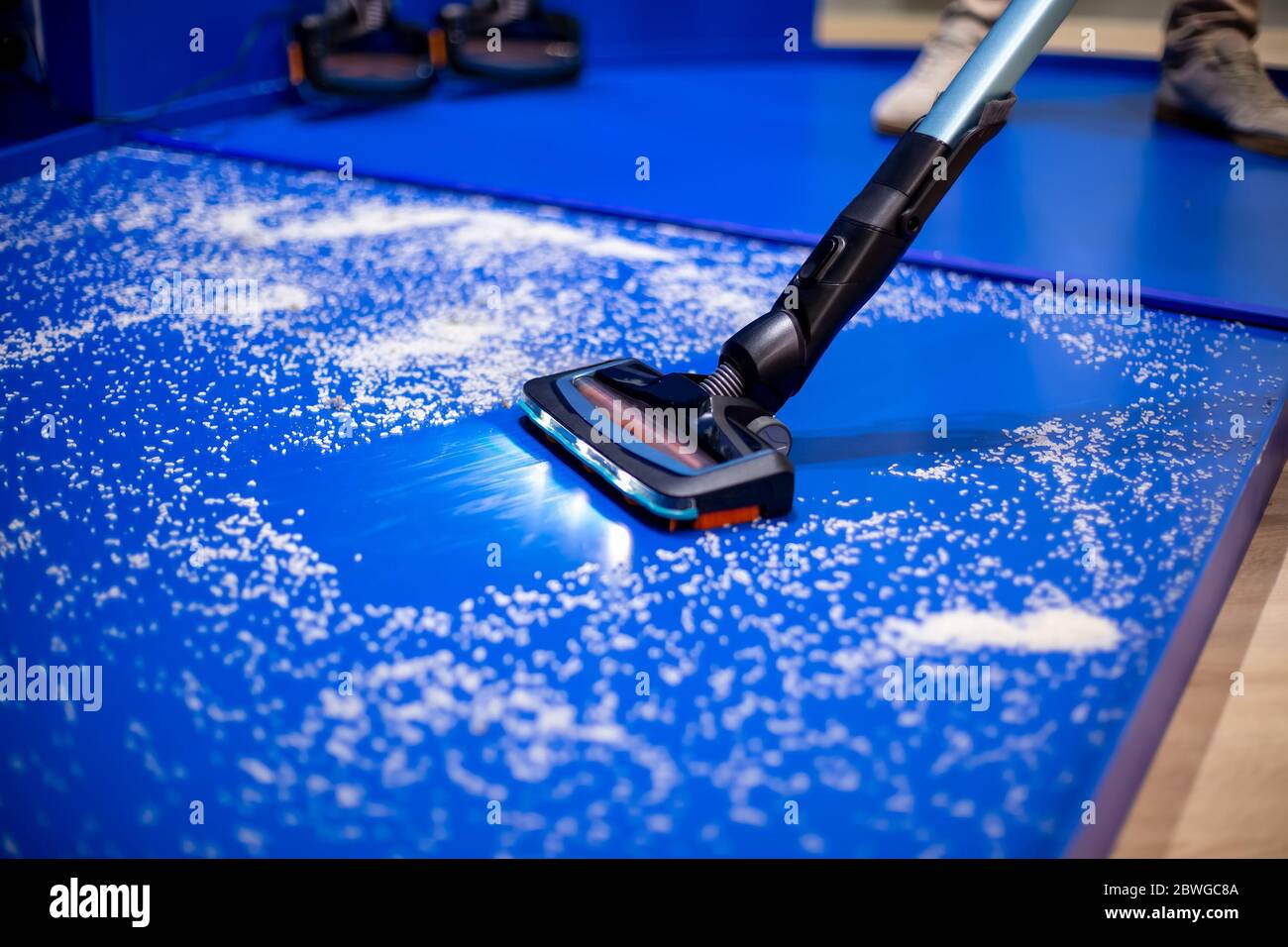 Un nouvel aspirateur avec nettoyage à l'eau et LED nettoie le sol bleu des  miettes blanches. Gros plan, mise au point douce Photo Stock - Alamy