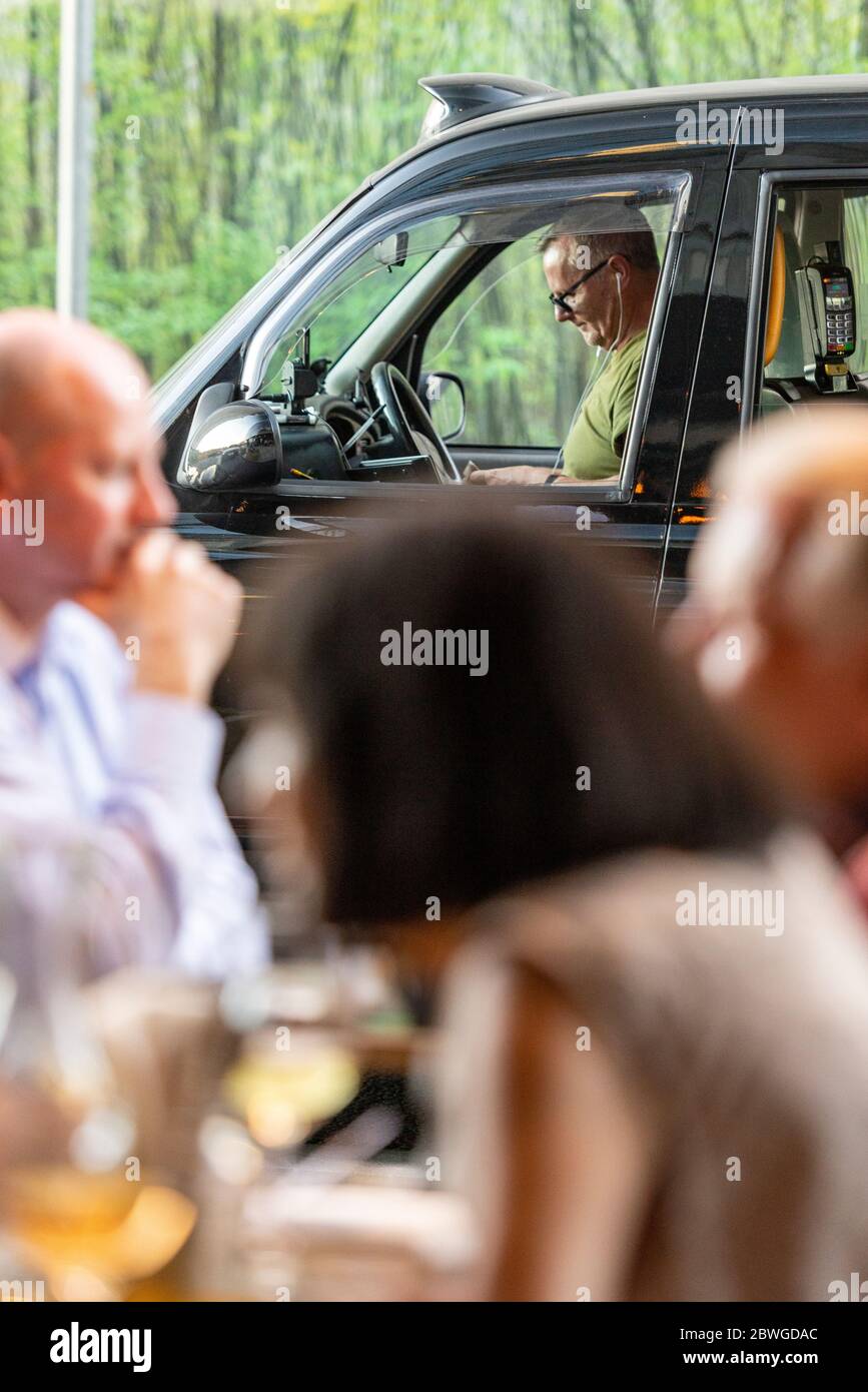 Un célèbre taxi londonien noir attend un passager à l'extérieur Une piste de restaurant très fréquentée dans la centrale électrique de Battersea New redéveloppement en neuf ormes Banque D'Images