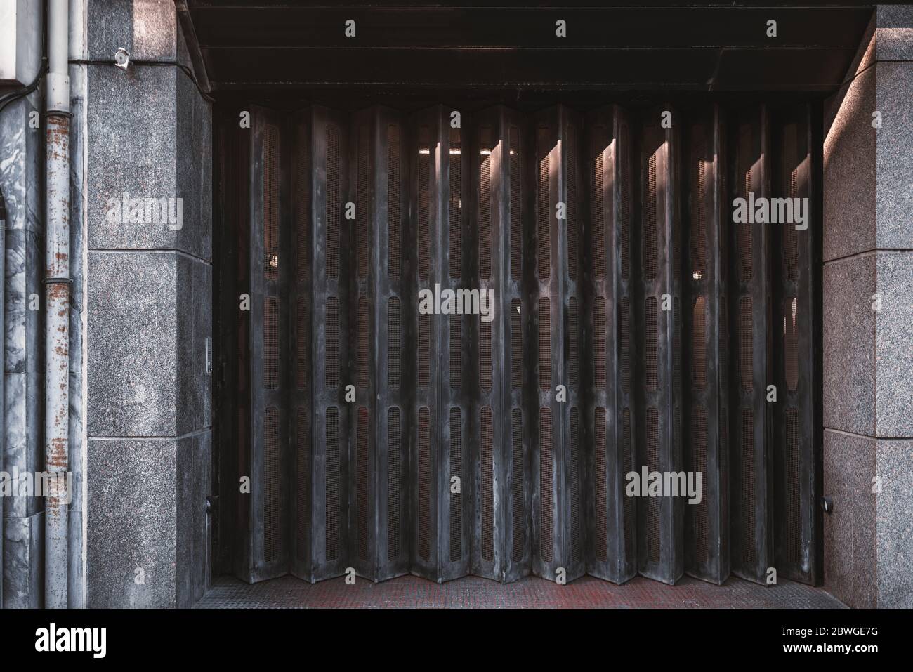 Garage ou entrée fermé portes métalliques texture avec lignes verticales brunes de la porte; vue avant d'une porte d'un grand g pliée en accordéon Banque D'Images