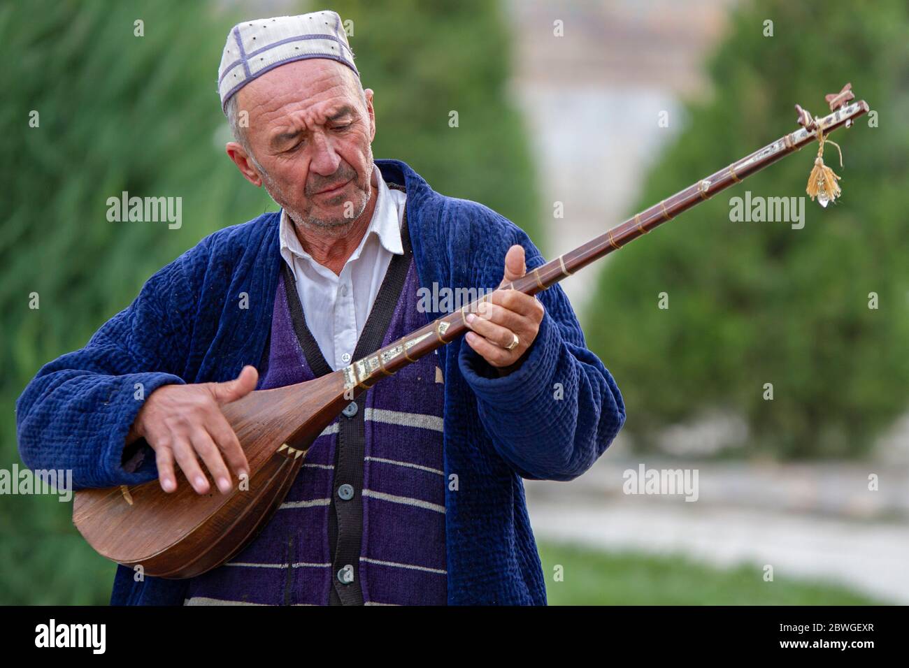 Ouzbek jouant un instrument de musique local, connu sous le nom de Dutar, à Samarkand, Ouzbékistan Banque D'Images