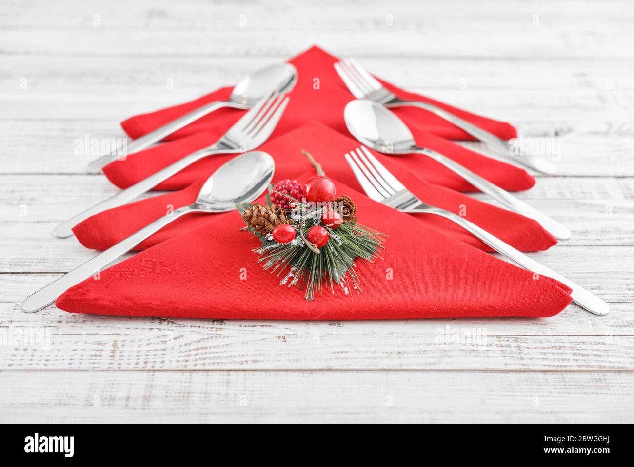 Serviettes rouges en forme d'arbre de Noël avec fourchettes et cuillères sur fond de bois Banque D'Images