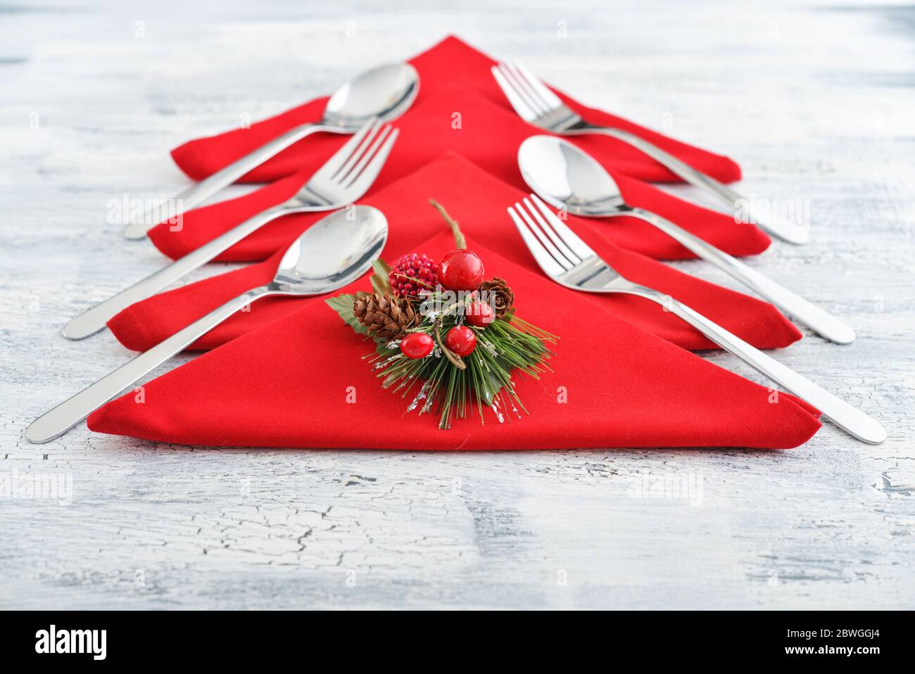 Serviettes rouges en forme d'arbre de Noël avec fourchettes et cuillères sur fond de bois Banque D'Images