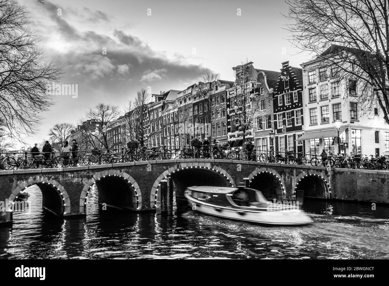 Belle scène tranquille de ville d'Amsterdam au crépuscule. Les vélos le long de la rue et sur le pont sur le canal. Banque D'Images