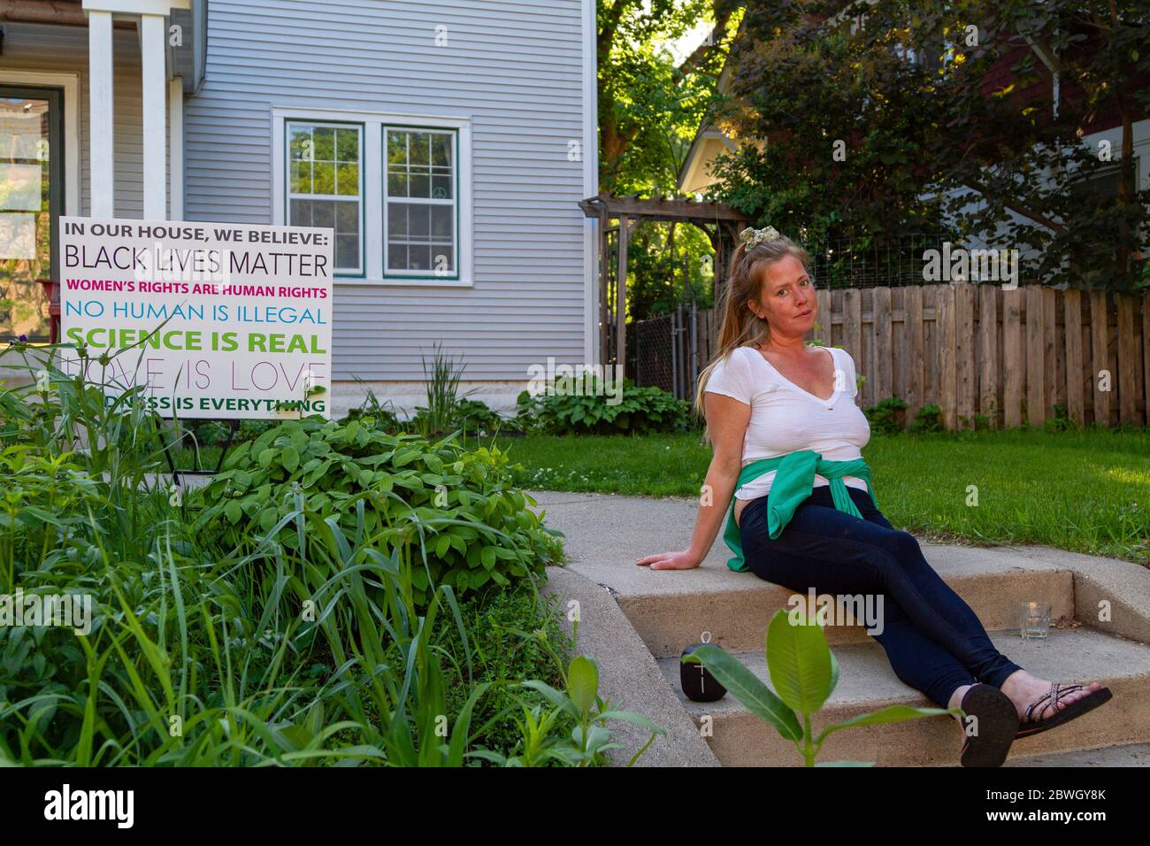 Minneapolis, États-Unis. 30 mai 2020. Minneapolis, MN - 30 mai 2020 : une femme assise devant une maison avec un panneau à la scène des séquelles du George Floyd Black Lives fait des manifestations et des émeutes le 30 mai 2020 à Minneapolis, Minnesota. Crédit: Jake Handegard/l'accès photo crédit: L'accès photo/Alamy Live News Banque D'Images