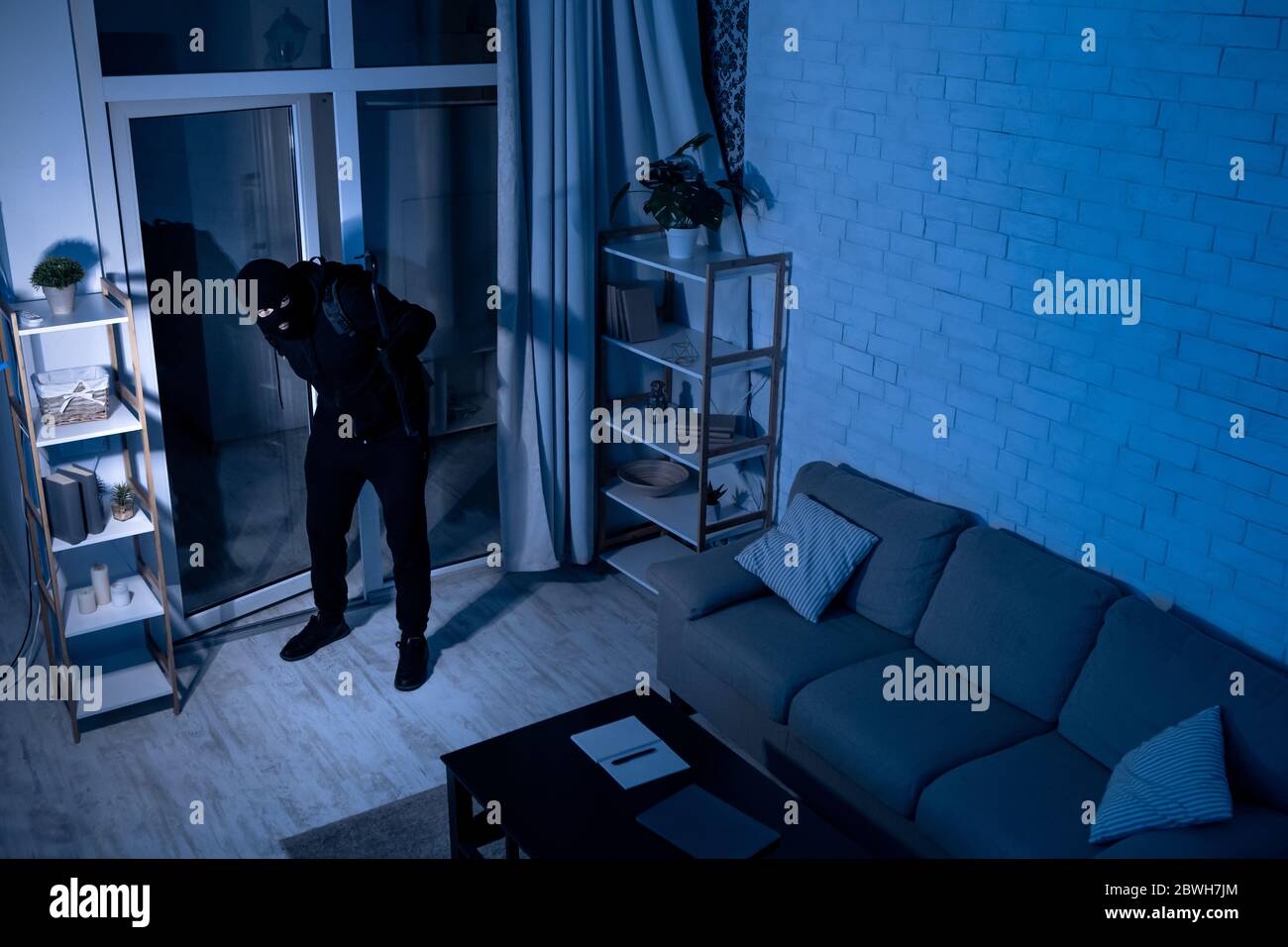 Voleur avec Crowbar entrant dans la vue de la maison à partir de la caméra Banque D'Images