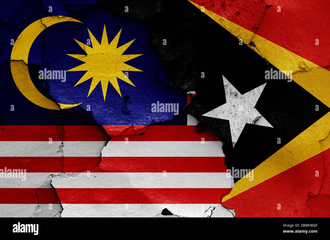 Drapeaux de Malaisie et du Timor oriental peints sur un mur fissuré Banque D'Images