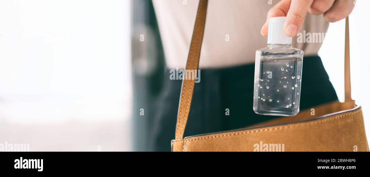 Désinfectant pour les mains flacon de voyage femme portant dans un sac à main COVID-19 prévention gel alcool pour nettoyer les mains à l'extérieur des courses. Bannière panoramique du virus coronavirus pandémique. Banque D'Images