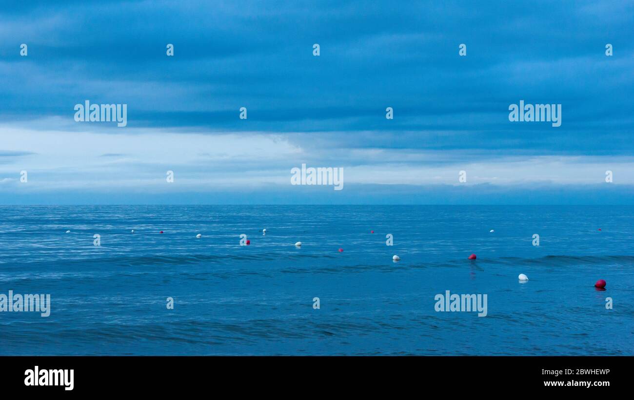 Bouées de natation marquant le périmètre d'une zone de baignade surveillée. Eaux ondulées au crépuscule. Cavendish Beach, parc national du Canada de l'Île-du-Prince-Édouard Banque D'Images