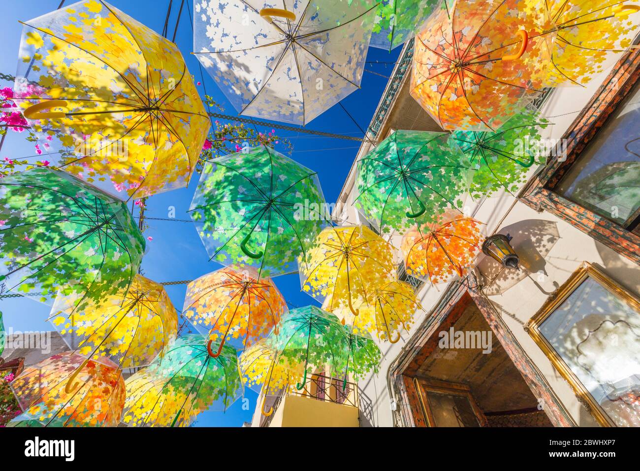 Rue de la vieille ville décorée de parasols de différentes couleurs le jour ensoleillé d'été, Grèce, île d'Aegina, Europe Banque D'Images