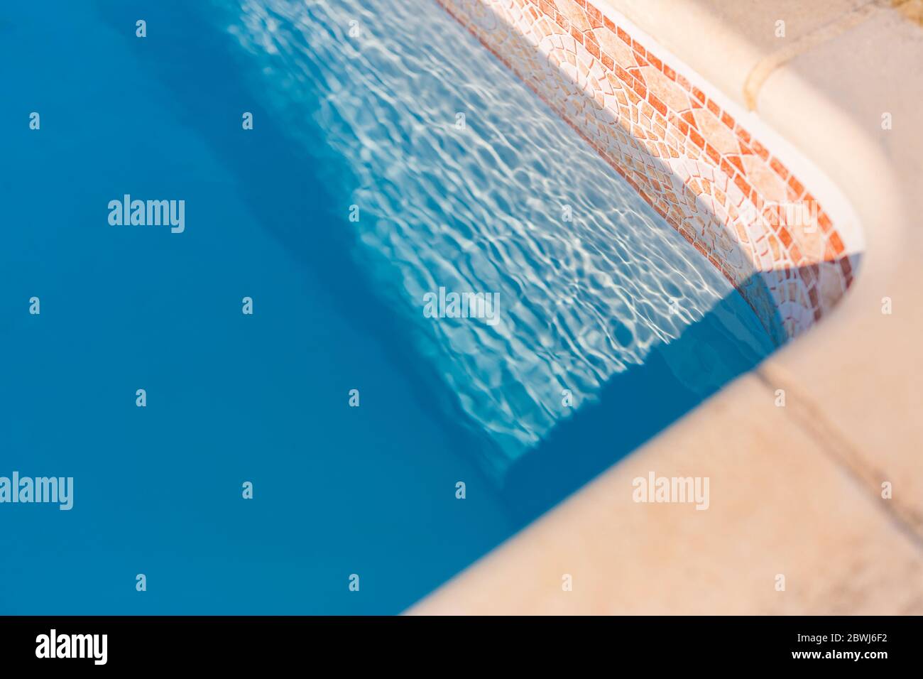 Bord de la piscine. Vacances d'été et humeur de vacances, piscine de luxe avec eau bleue et lumière du soleil, natation abstraite et activité de loisirs Banque D'Images