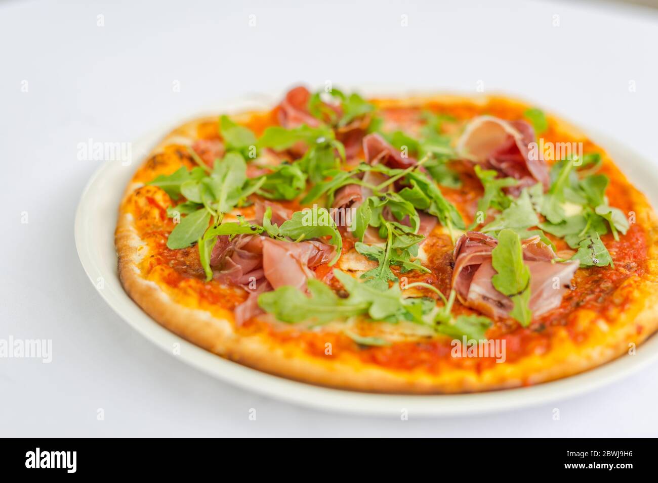Savoureuse pizza végétarienne avec tomates cerises, mozzarella et origan frais. Gros plan sur les aliments Banque D'Images