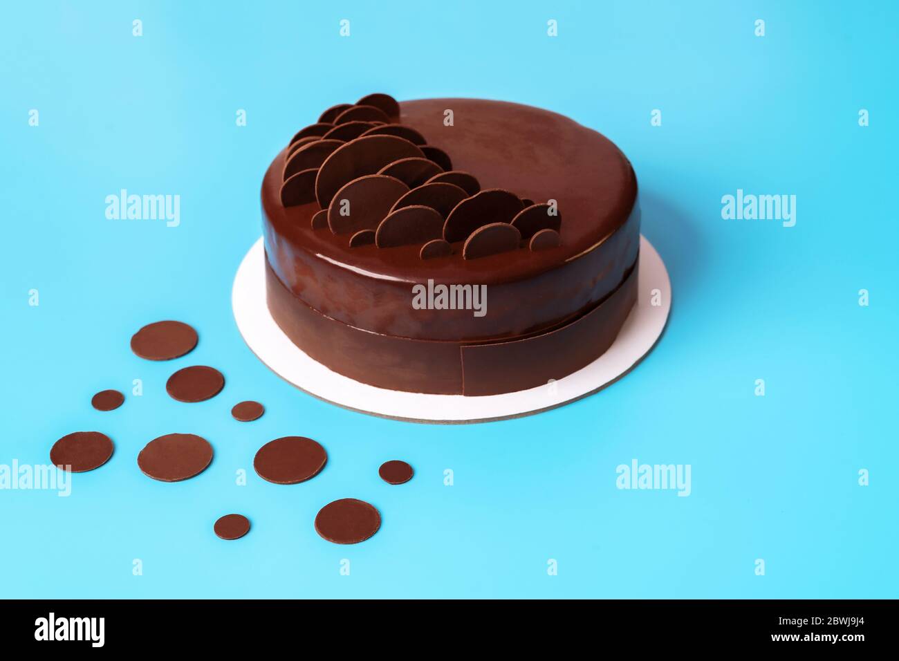 Gateau A La Mousse Au Chocolat Noir Recouvert De Glace Miroir Et Decore De Copeaux De Chocolat Ronds Sur Fond Bleu Gateau Moderne Et Elegant Gros Plan Copier Photo Stock Alamy
