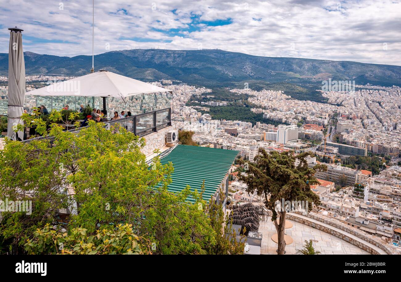 Les gens dans un café au sommet du mont Lycabette, profitant de la vue imprenable sur la ville depuis le haut. Banque D'Images
