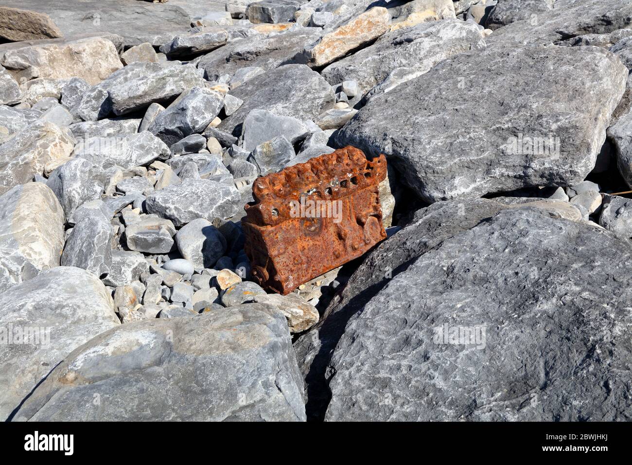 Un vieux petit moteur de voiture s'est lavé sur les rochers à ce point de beauté bien connu pris dans les rochers énormes de la baie. Banque D'Images