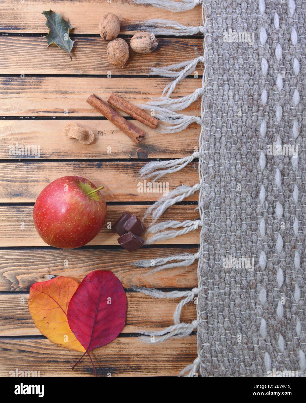 vue du haut la vie d'automne encore avec la feuille rouge, la pomme et les épices sur un woodenfarines à côté de la moquette de laine Banque D'Images