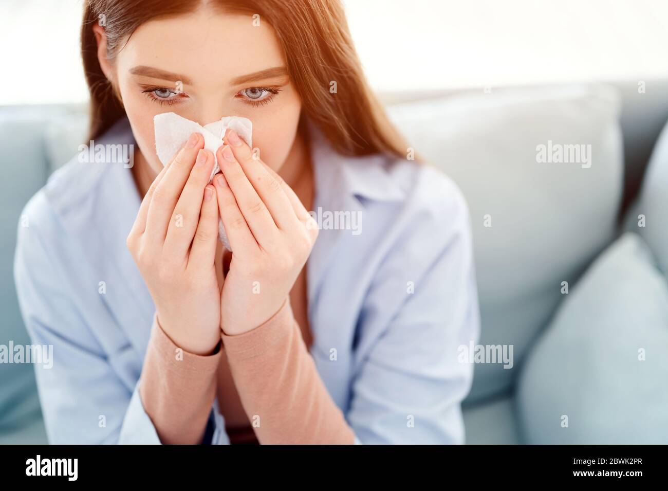La femme malade a le nez courant en utilisant dans le papier de soie. Rhinite, froid, maladie, frotte le nez avec le mouchoir. Éternuer femme Banque D'Images