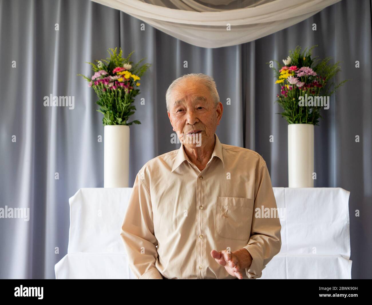 Un homme asiatique âgé prononce un discours lors d'un événement familial Banque D'Images