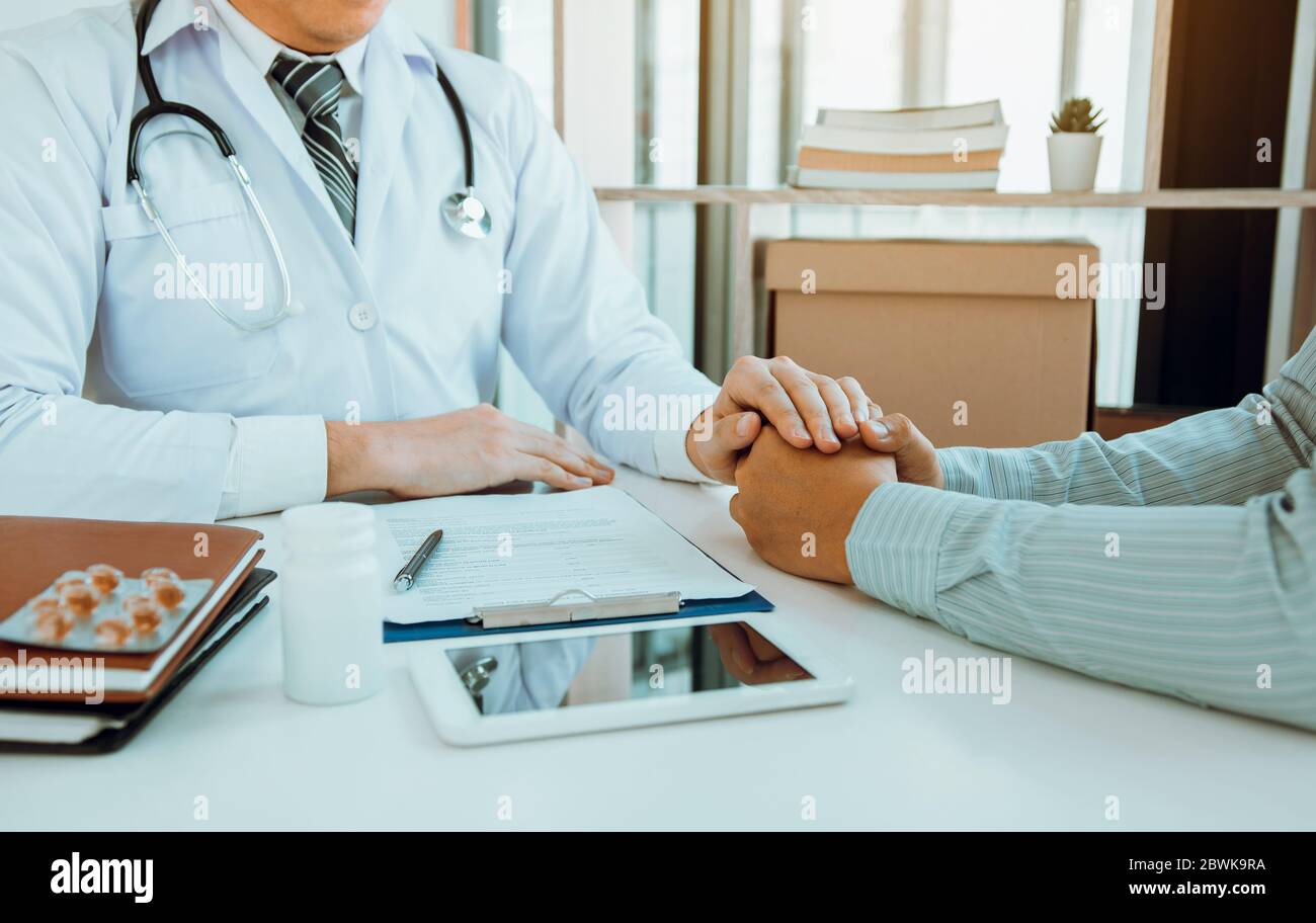 Le médecin a serré les mains et consolé les patients qui s'inquiétaient du traitement. Banque D'Images