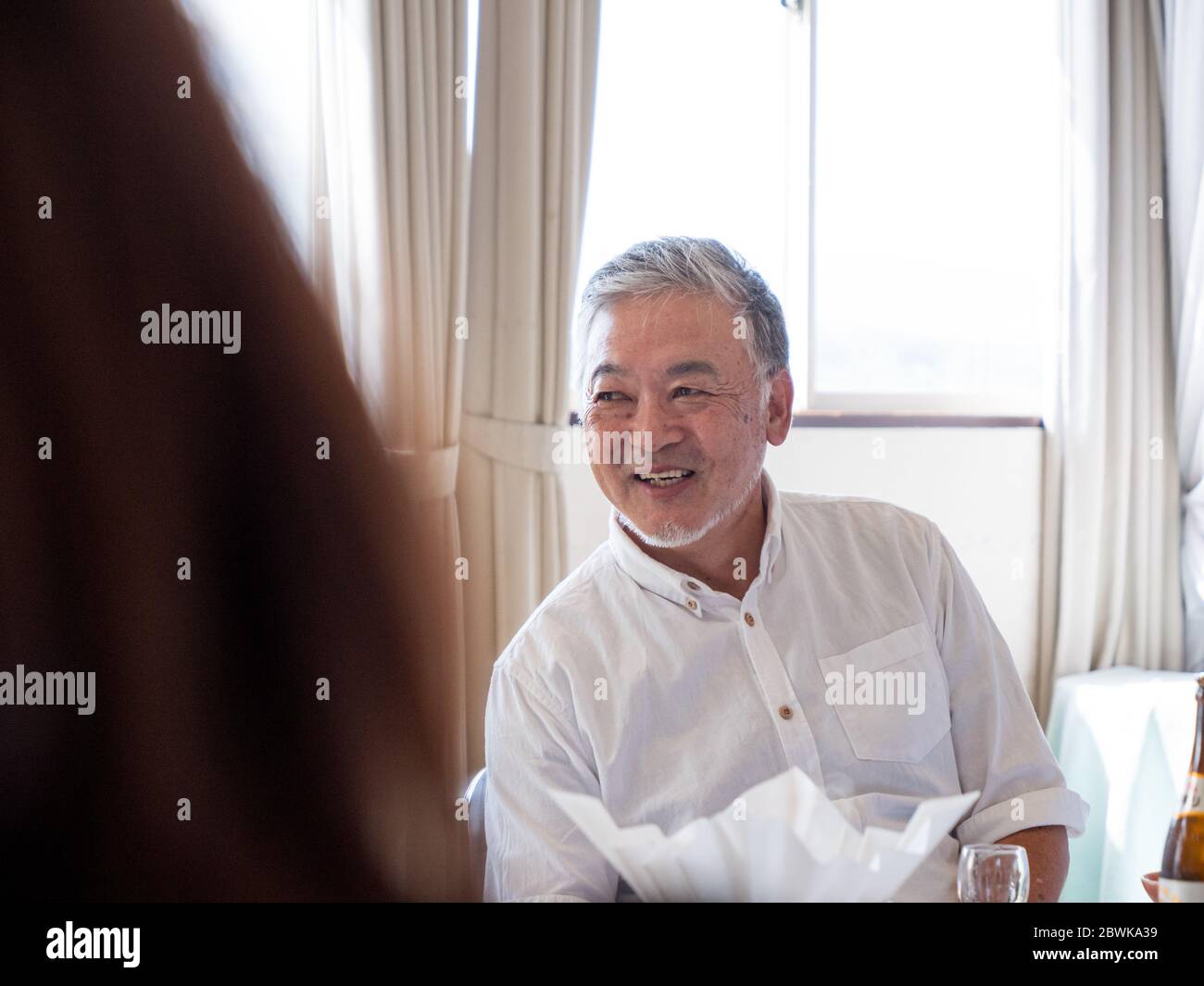 Un beau homme plus âgé sourit de l'appareil photo Banque D'Images