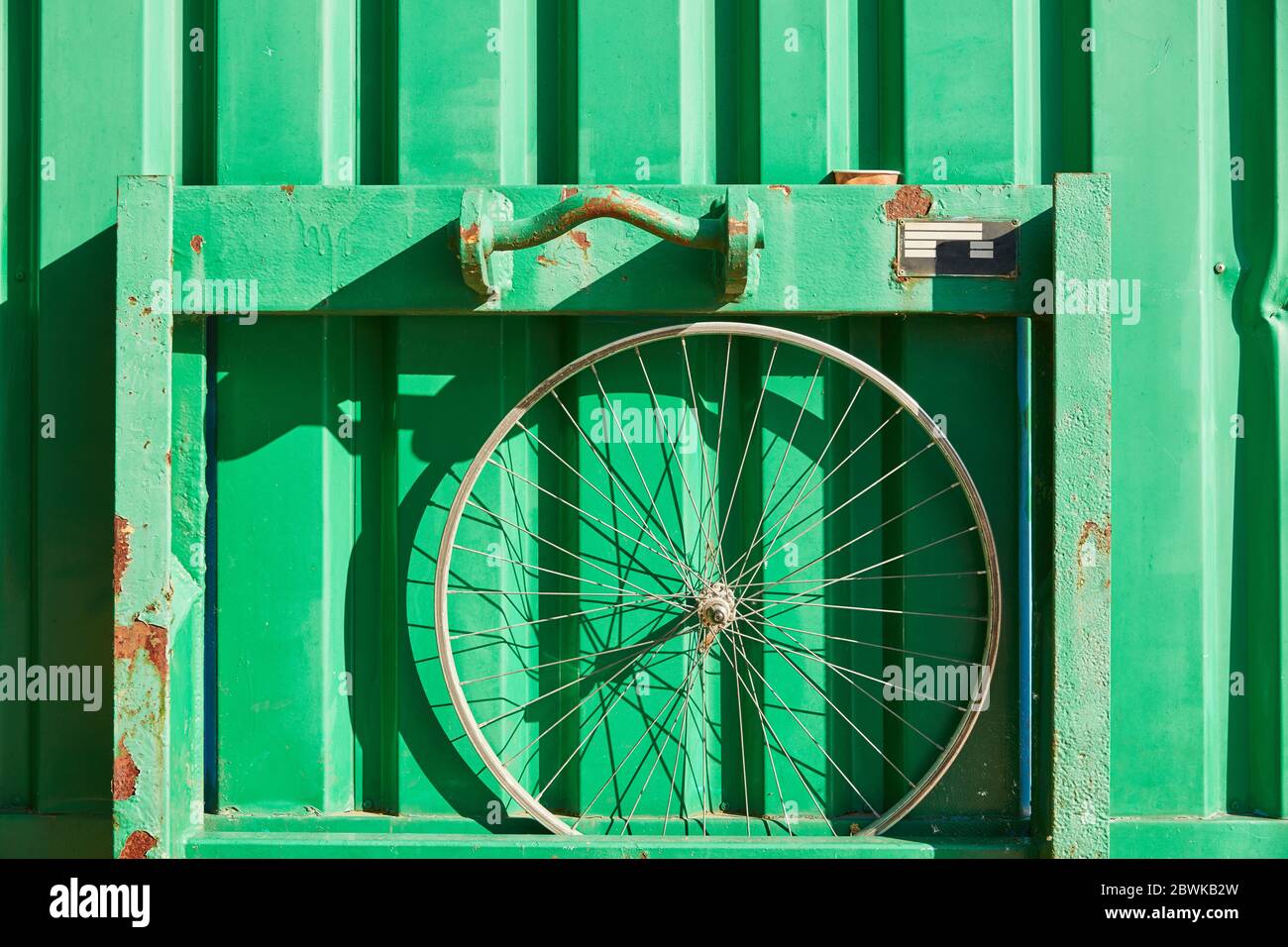 La jante de roue avant sur un récipient vert comme texture de fond Banque D'Images