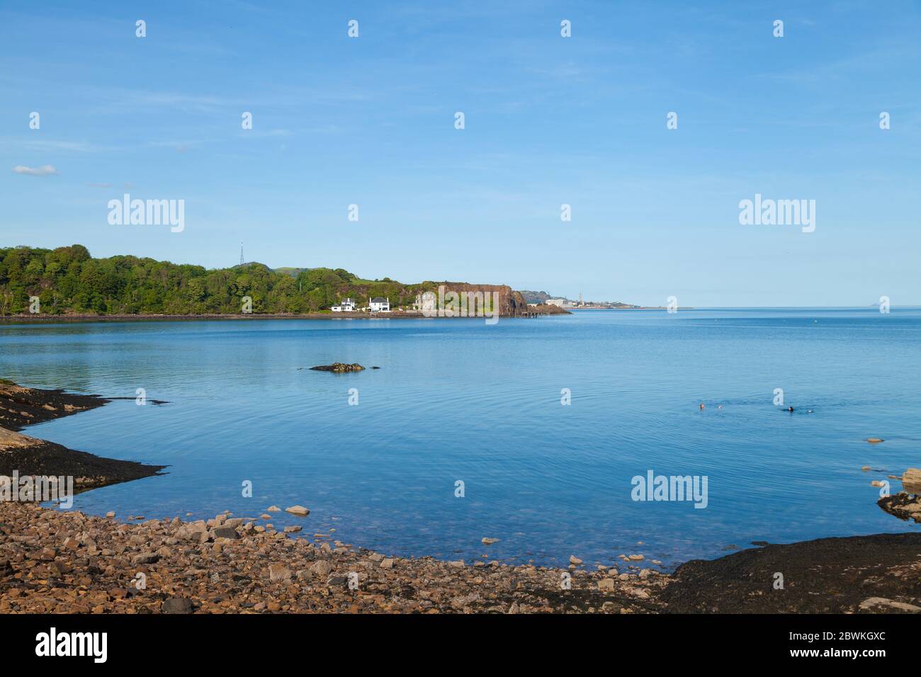 Deux personnes nageant dans une mer plate à la palourdes à Aberdour, Fife, Écosse. Banque D'Images