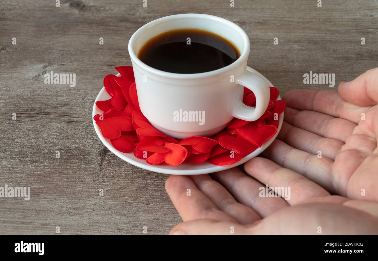 Tasse de café parfumé. Tasse et mains pour hommes. Thème romantique, faire du café avec amour. Banque D'Images