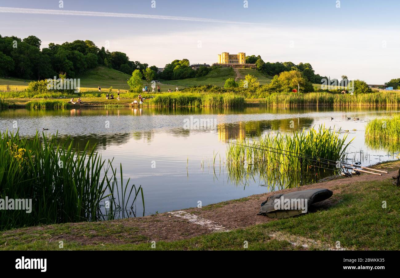 Bristol, Angleterre, Royaume-Uni - 27 mai 2020 : les gens s'assoient au soleil le soir et pêchent dans l'étang de la Duchesse à Stoke Park, au nord de Bristol, avec le beh de la Dower House Banque D'Images