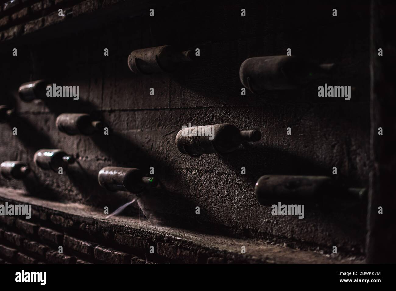 Ancienne collection de vins et bouteilles de vin poussiéreuses dans une cave souterraine Banque D'Images