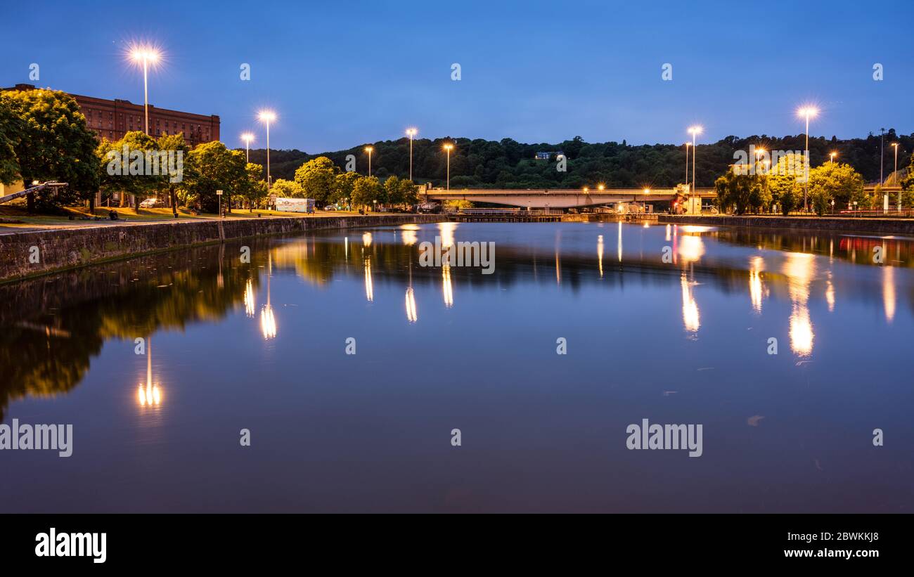 Les réverbères éclairent les quais et le réseau routier lorsque la tombée de la nuit tombe sur le bassin Cumberland, dans le port flottant de Bristol. Banque D'Images