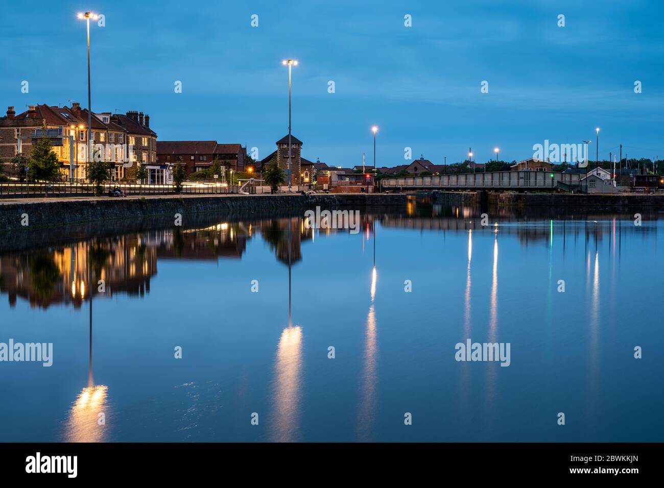 Bristol, Angleterre, Royaume-Uni - 21 mai 2020 : la circulation laisse des sentiers légers sur la A4 Cumberland Basin Road, tandis que la tombée de la nuit tombe sur le port flottant de Bristol. Banque D'Images