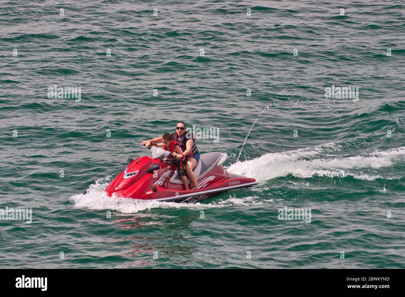 Femme et enfant à bord d'un bateau personnel (PWC), également appelé scooter des eaux, sur Canyon Lake, réservoir artificiel dans Hill Country, Texas, États-Unis Banque D'Images