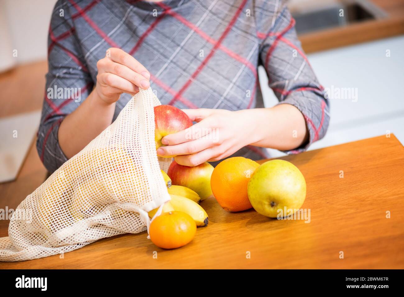 Packs ECO. Une femme sort des fruits après avoir fait ses achats dans un sac Eco. Sacs anti-plastique. Zéro déchet. Banque D'Images