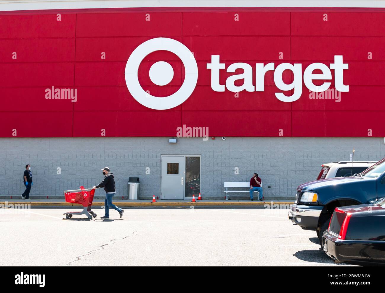 Bay Shore, New York, États-Unis - 25 avril 2020 : le logo d'un magasin cible sur l'extérieur des bâtiments faisant face au stationnement avec des personnes portant un masque facial A. Banque D'Images