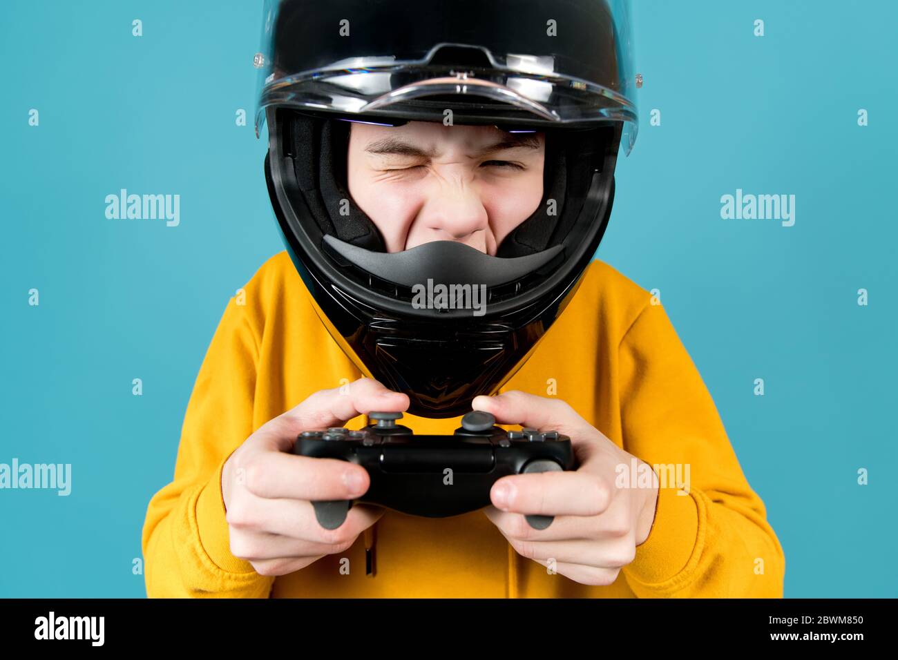 un adolescent dans un casque de moto avec un joystick de une console de  jeux se déforme Photo Stock - Alamy