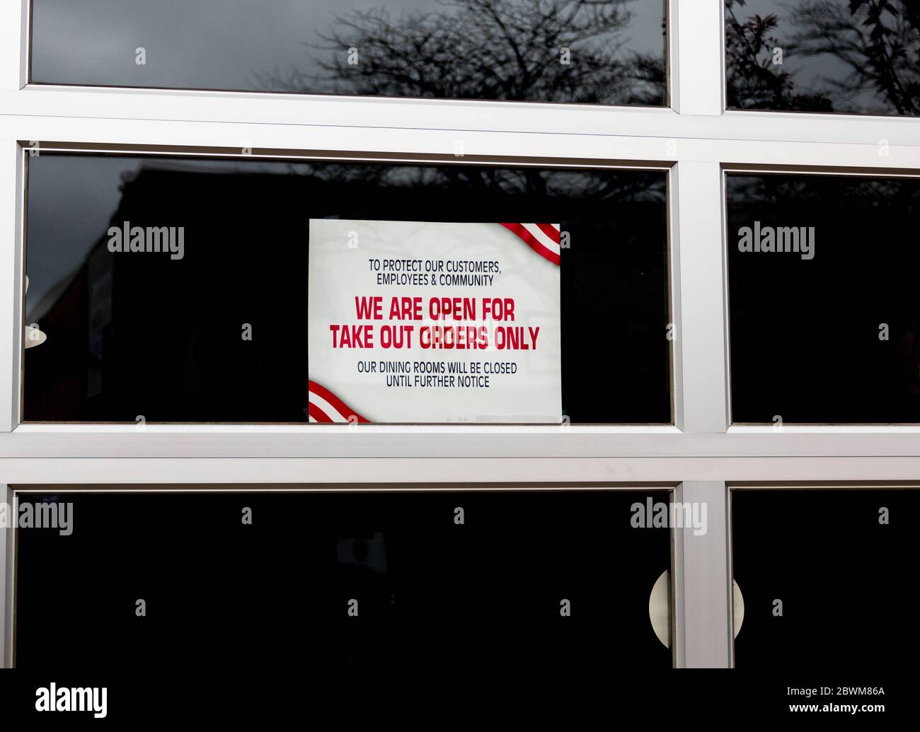En raison de la pandémie du coronavirus, un restaurant a un panneau dans sa fenêtre de lecture pour protéger nos clients et nos employés nous sommes ouverts pour prendre des commandes Banque D'Images En raison de la pandémie du coronavirus, un restaurant a un panneau dans sa fenêtre de lecture pour protéger nos clients et nos employés nous sommes ouverts pour prendre des commandes Banque D'Images